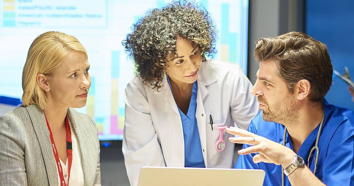 three healthcare professionals discussing managing knowledge for healthcare improvement